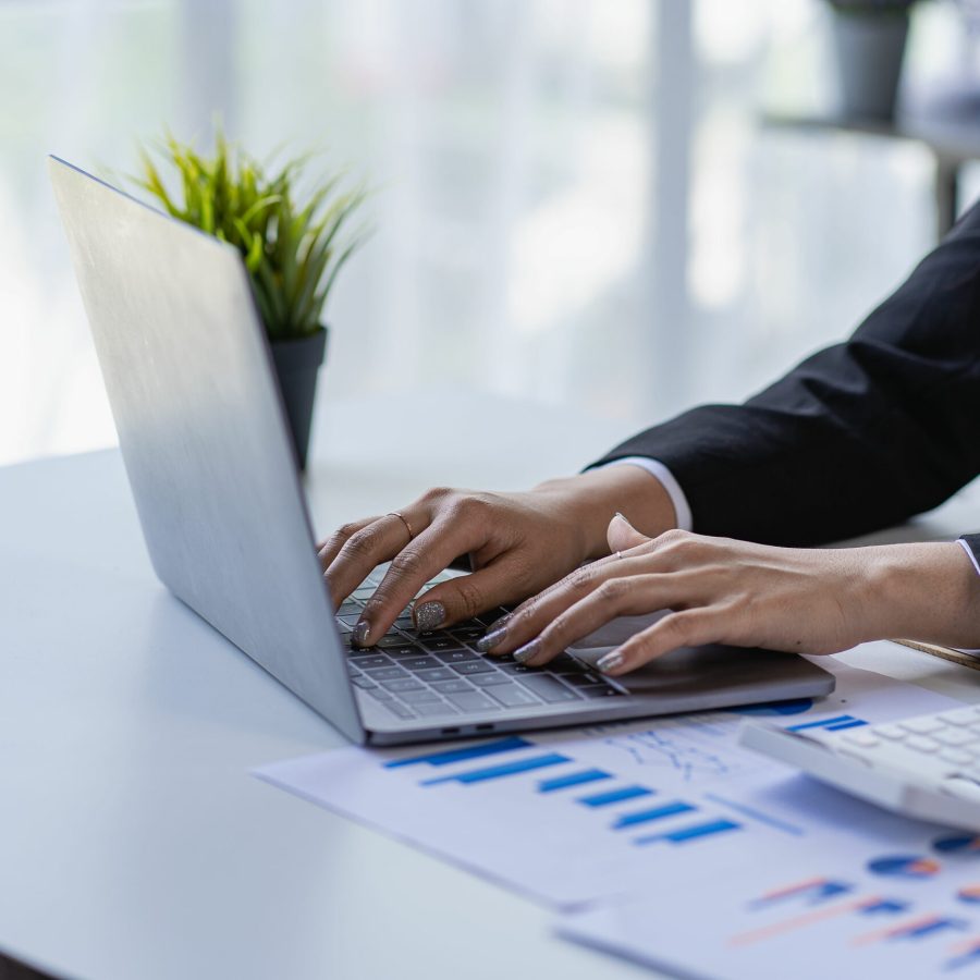 Close up of businesswoman hand holding pen and pointing at financial document Financial charts to analyze with documents on the table planning financial report business plan profit investment concept